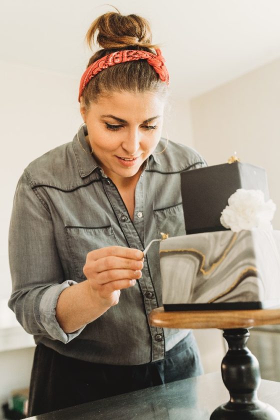 Charlène décore un gâteau de mariage