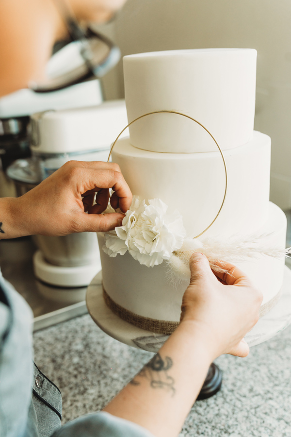 Charlène décore un gâteau de mariage